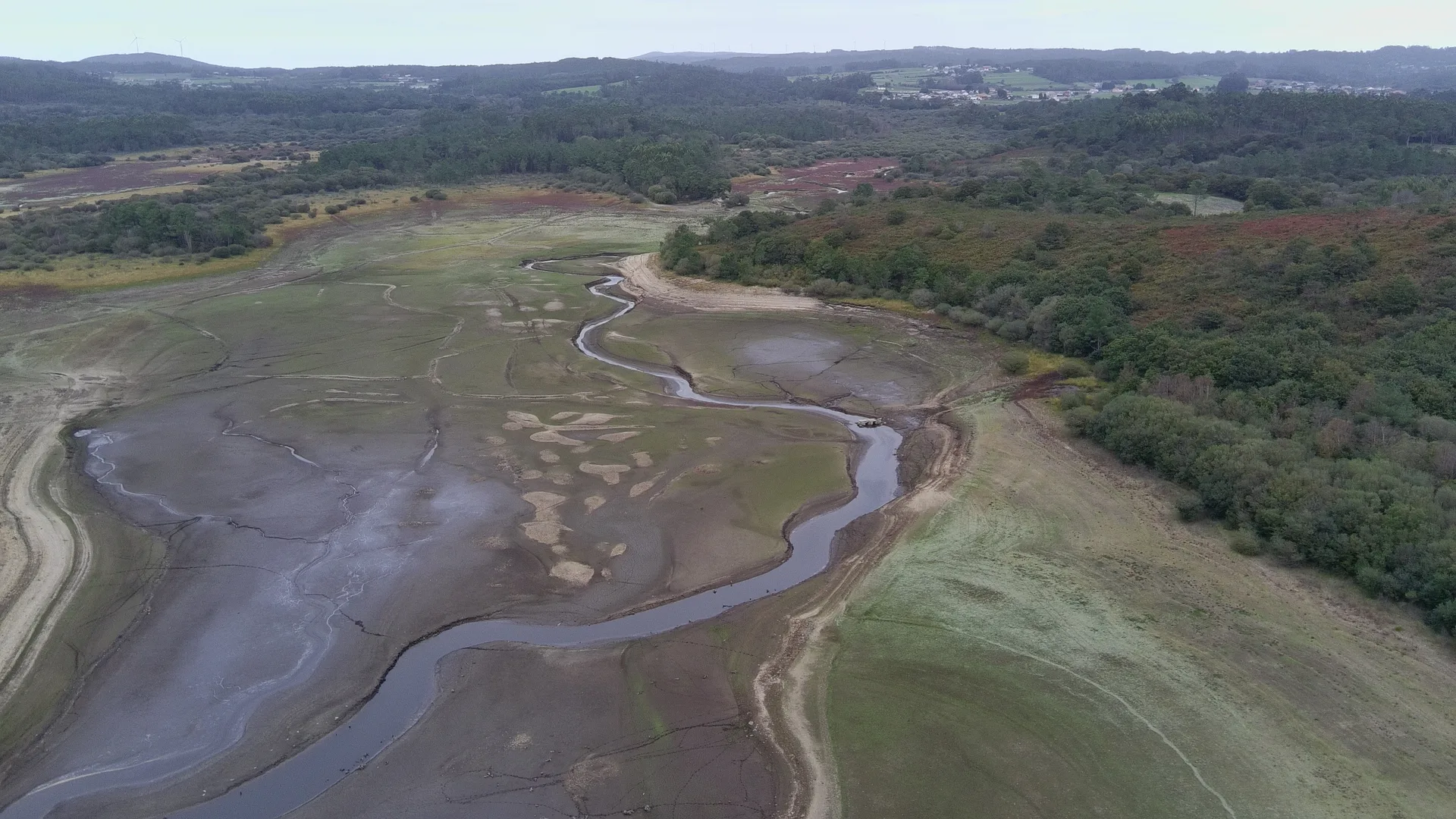 Vista aérea do encoro da Fervenza co nivel moi baixo, o leito descuberto e o antigo curso do Xallas serpeando polo fondo